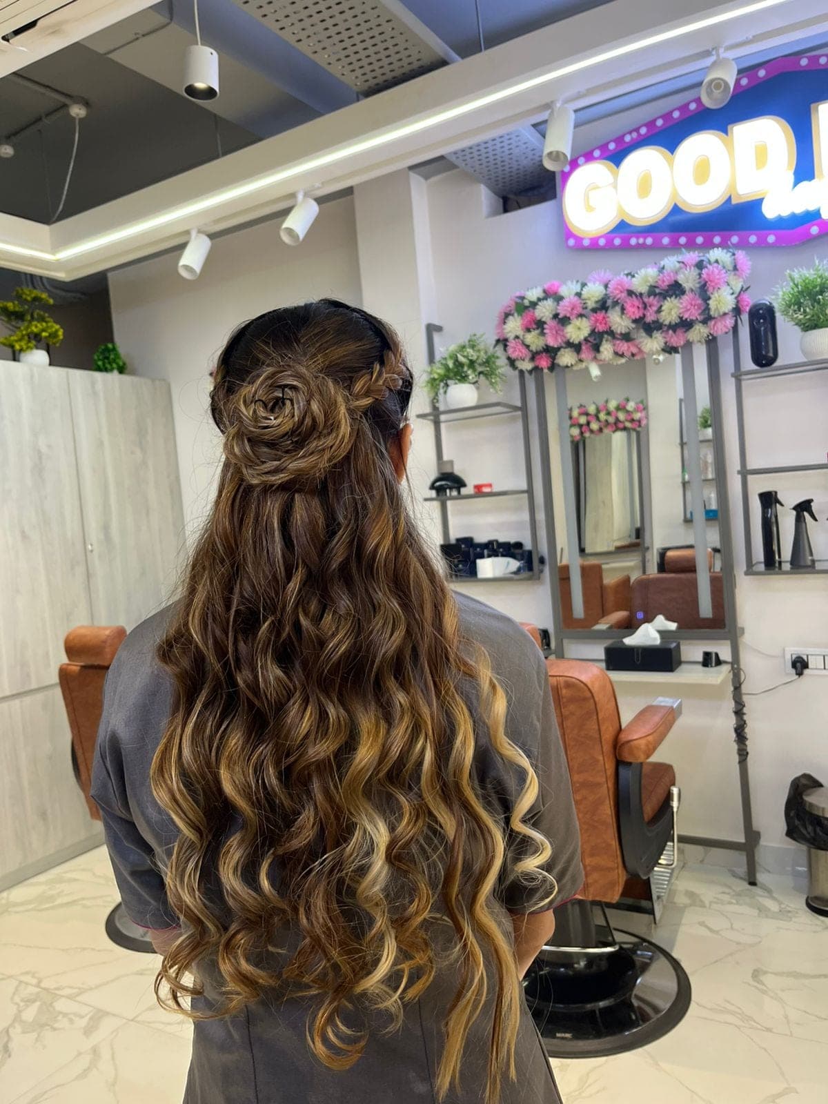 Client at Lakmé Salon Rajajipuram with a rose-braided half-up and long balayage waves