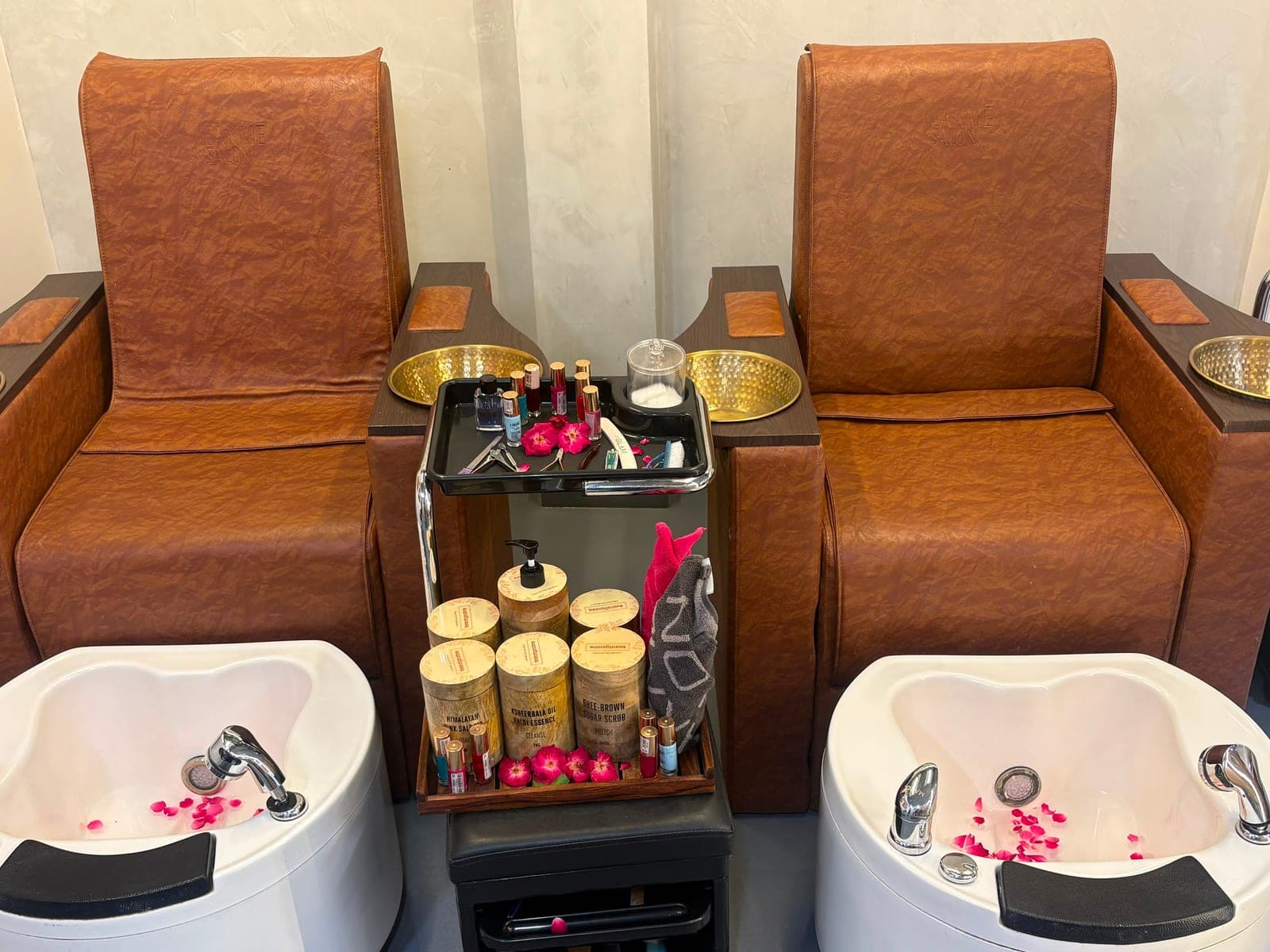Paired pedicure chairs and brass basins at Lakmé Salon Rajajipuram