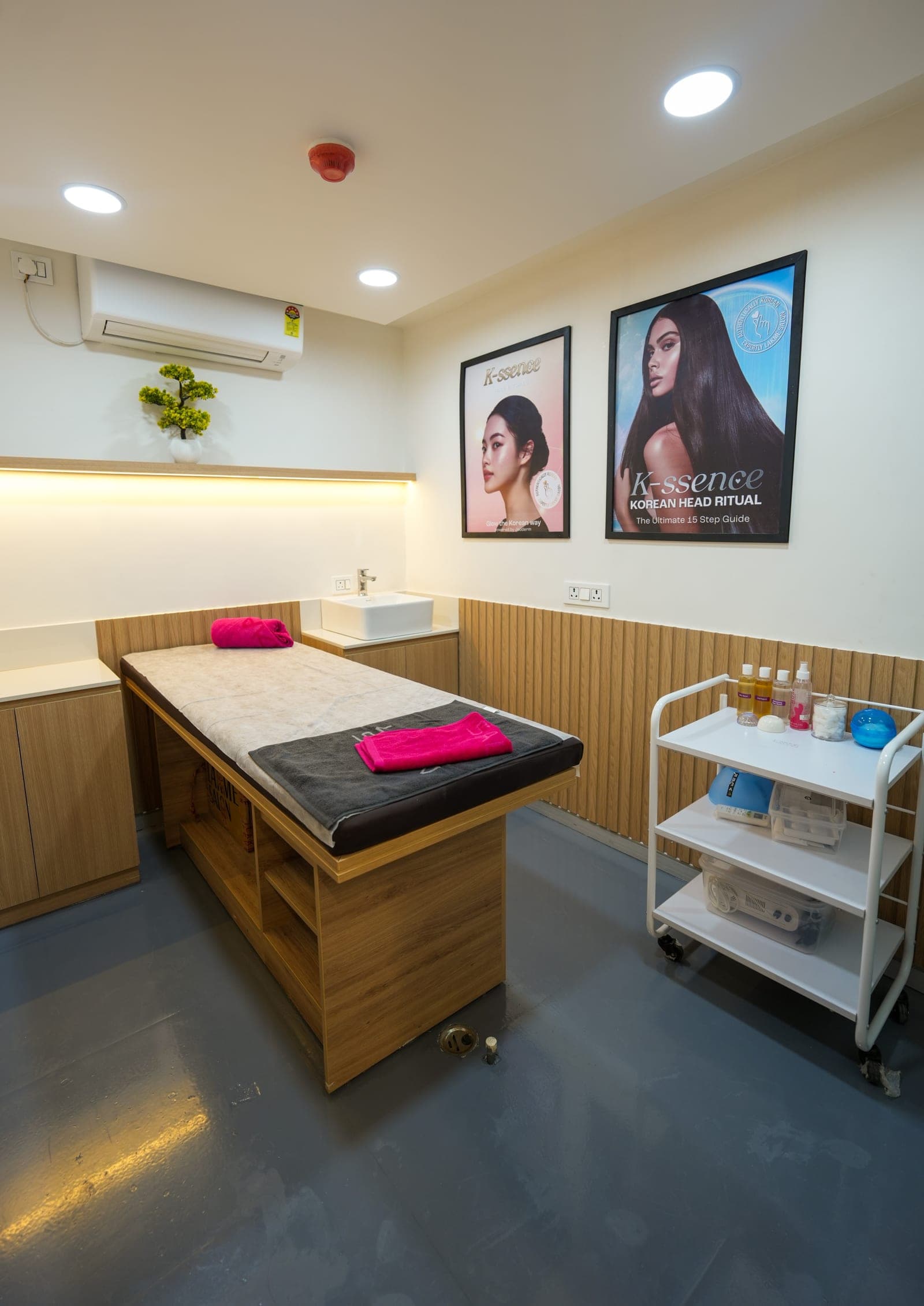 The private treatment room at Rajajipuram, bed made up beneath the K-Essence Korean Head Ritual panels